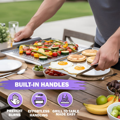 A person using built-in handles to carry the stainless steel grill plate filled with cooked vegetables and eggs from the grill to a wooden outdoor dining table.